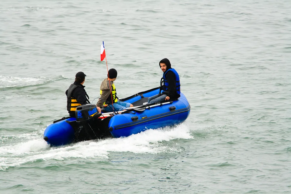 Navegación en bote azul con tripulantes a bordo