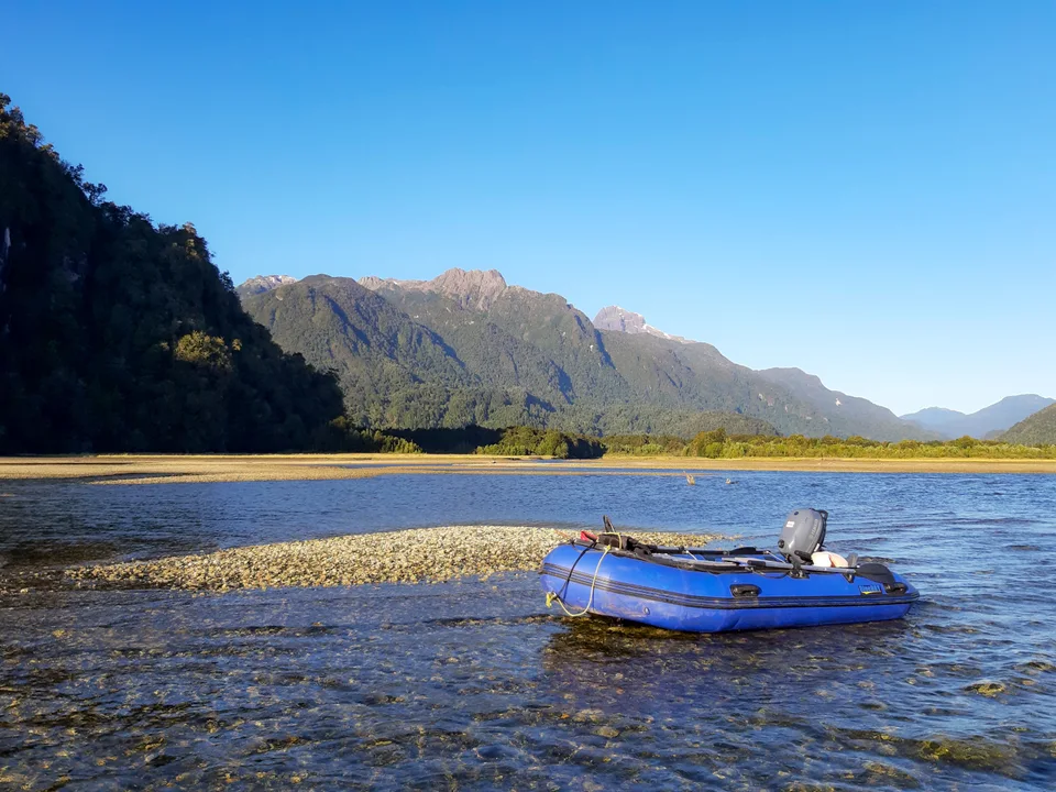 Bote azul junto a una playa de montaña