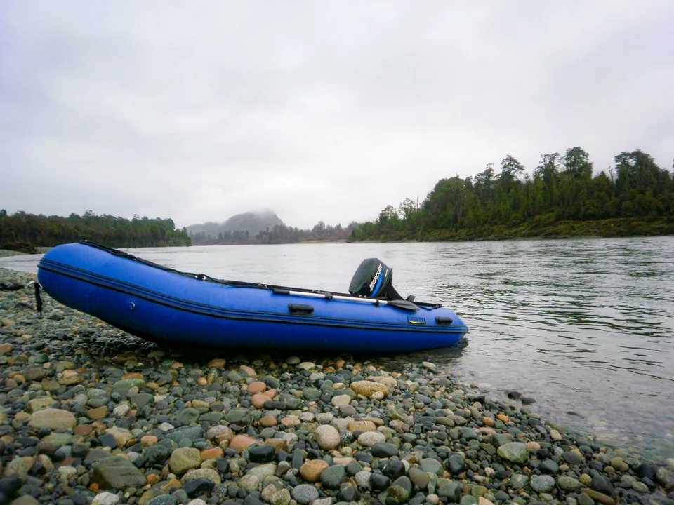Bote azul sobre una orilla de piedras