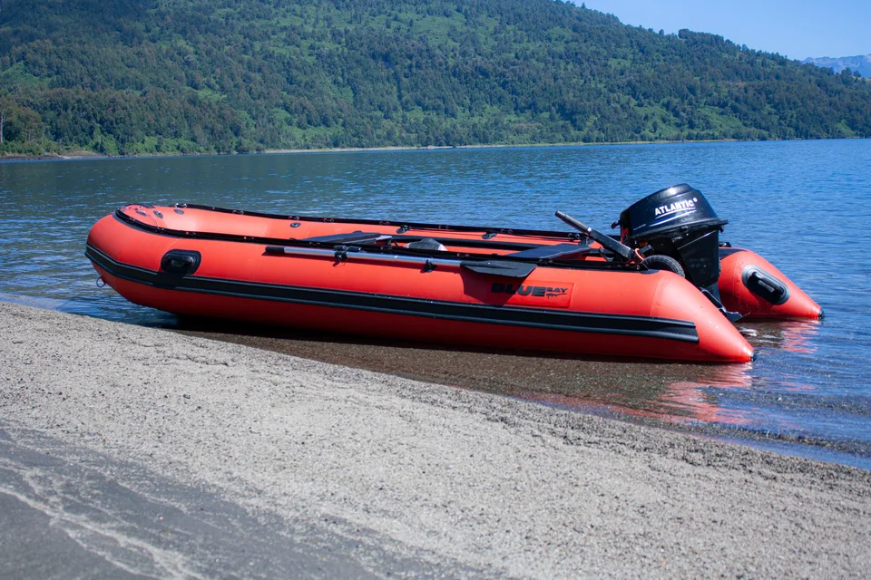 Bote rojo junto a la orilla de un lago