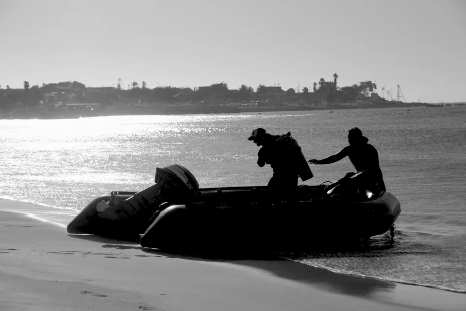 Dos tripulantes a bordo de un bote azul